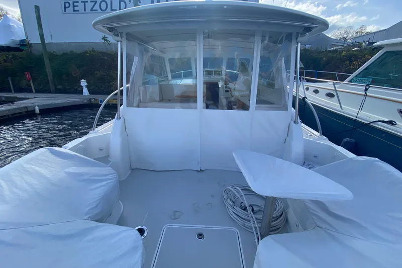 Slide: The Image of 2022 Back Cove 34O boat cruising on a scenic river with trees in the background. - 2