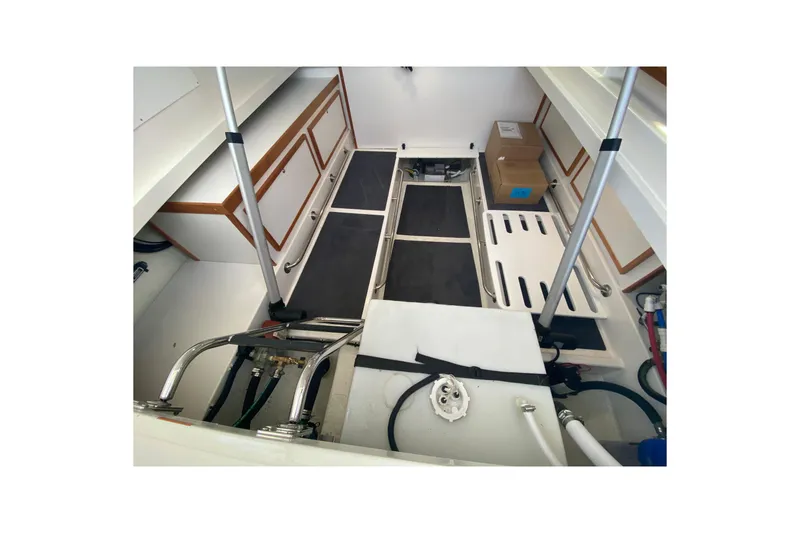 Slide: The Image of 2022 Back Cove 34O boat interior storage compartment with wooden finish and organized items. - 22