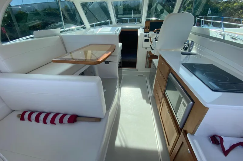 Slide: The Image of 2022 Back Cove 34O boat cruising on a river with trees in the background. - 3