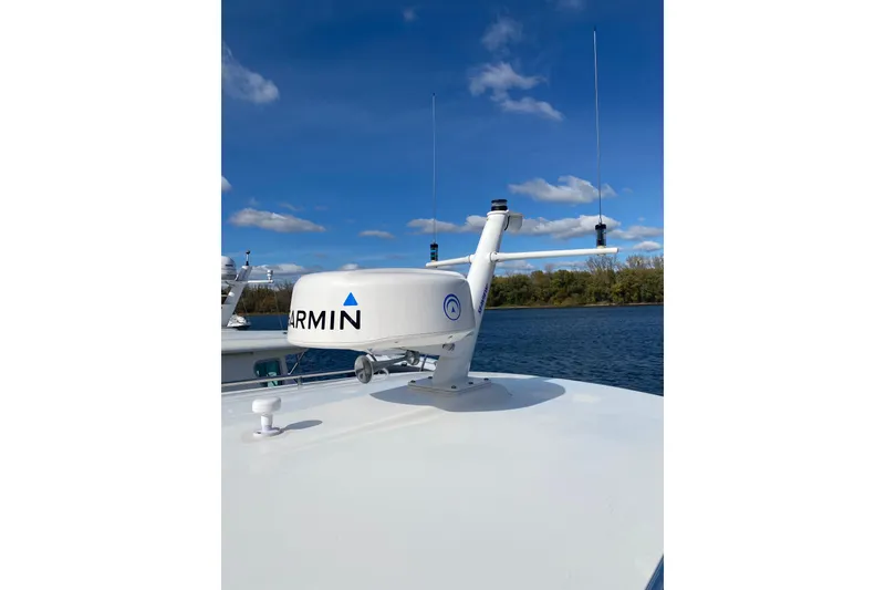 Slide: The Image of 2022 Back Cove 34O boat with Garmin radar on deck, under clear blue sky. - 35