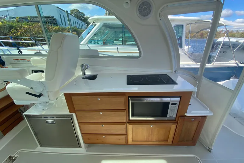 Slide: The Image of 2022 Back Cove 34O boat cruising on a lake with trees in the background. - 5