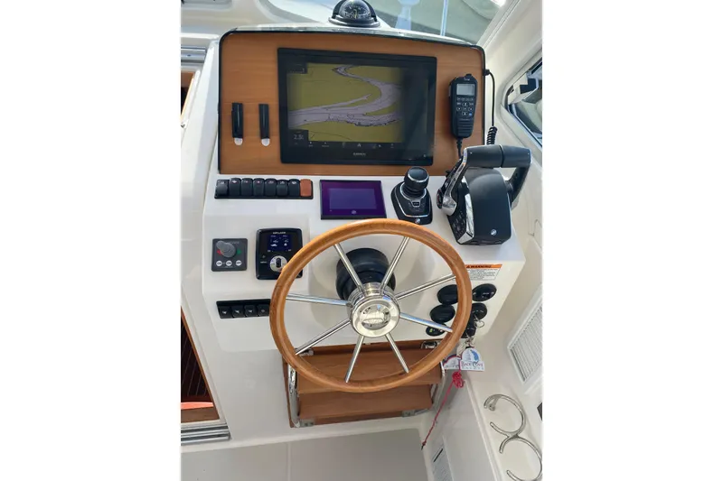 Slide: The Image of 2022 Back Cove 34O boat cruising on a calm lake under a clear blue sky. - 6