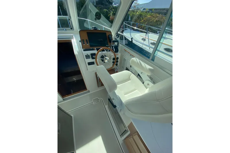 Slide: The Image of 2022 Back Cove 34O boat cruising on a calm river with trees in the background. - 7