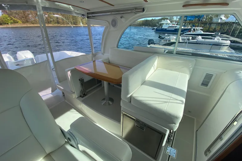 Slide: The Image of 2022 Back Cove 34O boat on a serene lake with a forested background. - 8