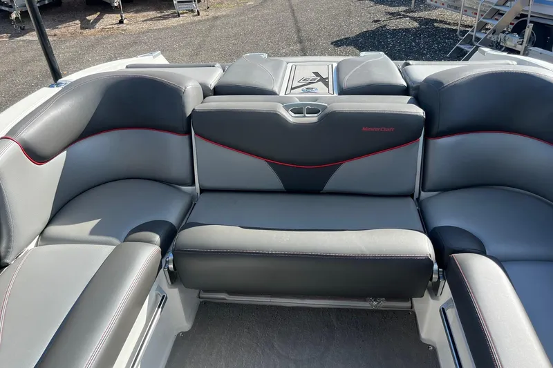 Slide: The Image of 2017 MasterCraft X23 boat interior with gray and black seating, red accents. - 10