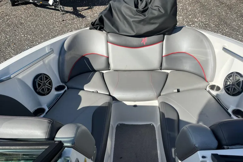 Slide: The Image of 2017 MasterCraft X23 boat interior with gray seating and red accents. - 9