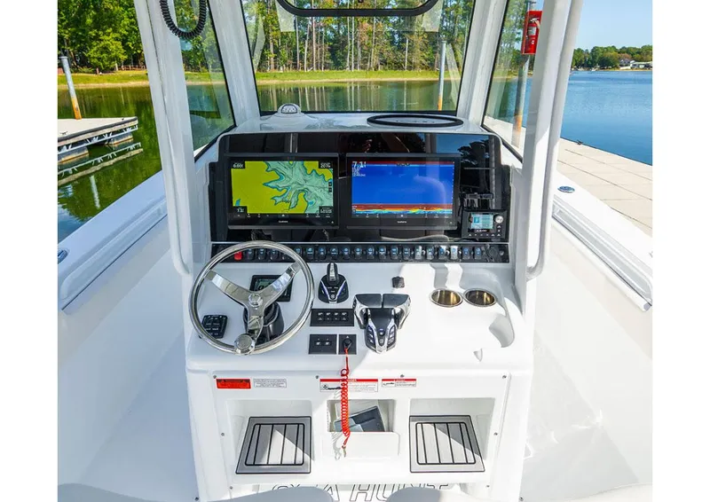 Slide: The Image of Manufacturer Provided Image: 2026 Sea Hunt Gamefish 28 Coffin Box helm with dual displays and controls, dockside view. - 5