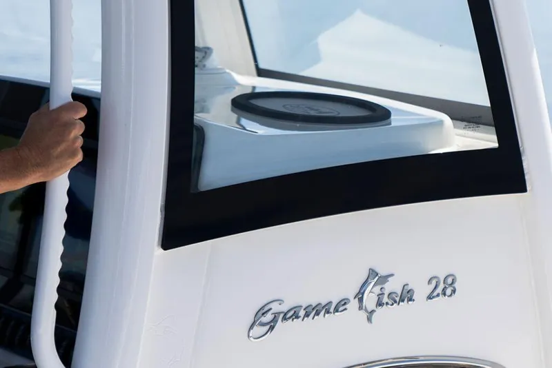 Slide: The Image of 2026 Sea Hunt Gamefish 28 Coffin Box boat detail with hand on railing. - 7