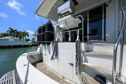 Slide: The Image of 1998 Hatteras 70 Cockpit Motor Yacht docked, featuring spacious deck and modern amenities. - 15