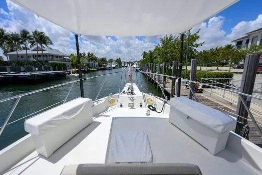 Slide: The Image of 1998 Hatteras 70 Cockpit Motor Yacht docked in a scenic marina setting. - 17