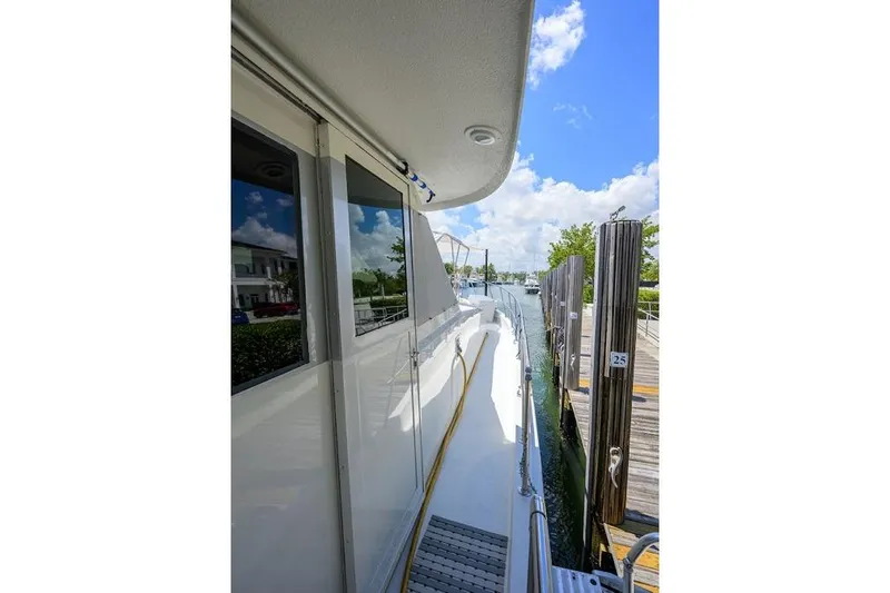 Slide: The Image of 1998 Hatteras 70 Cockpit Motor Yacht docked, showcasing sleek exterior and marina view. - 18
