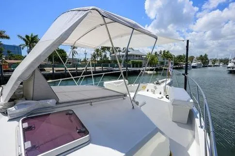 Slide: The Image of 1998 Hatteras 70 Cockpit Motor Yacht with canopy, docked in a sunny marina. - 20