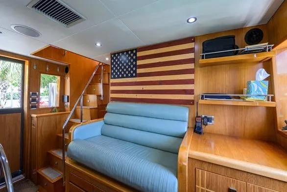 Slide: The Image of Interior of 1998 Hatteras 70 Cockpit Motor Yacht with American flag decor and wooden furnishings. - 22