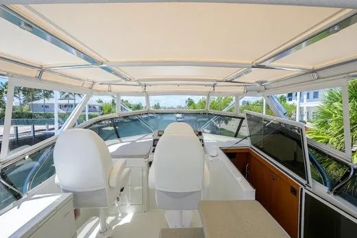 Slide: The Image of 1998 Hatteras 70 Cockpit Motor Yacht helm with white seating and panoramic views. - 25