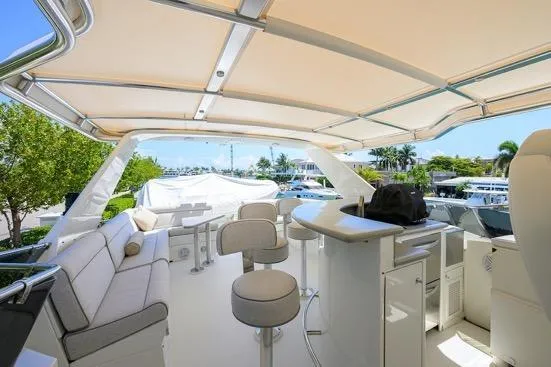 Slide: The Image of Luxurious 1998 Hatteras 70 Cockpit Motor Yacht with spacious outdoor seating and bar area. - 26