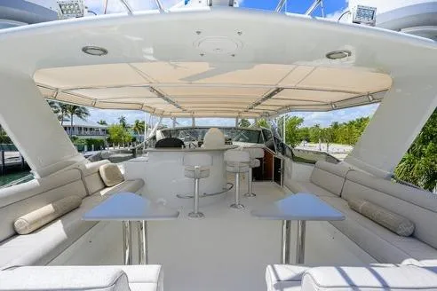 Slide: The Image of Luxurious 1998 Hatteras 70 Cockpit Motor Yacht with spacious outdoor seating and bar area. - 27