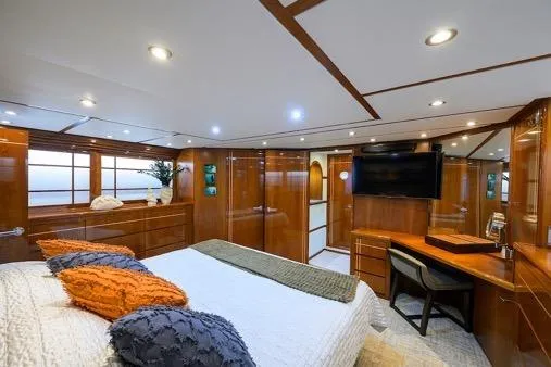 Slide: The Image of Luxurious bedroom interior of 1998 Hatteras 70 Cockpit Motor Yacht with wood paneling and modern amenities. - 30