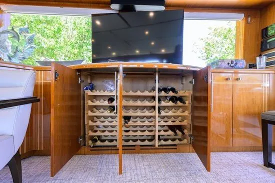 Slide: The Image of Luxurious 1998 Hatteras 70 yacht interior with wine storage and modern TV setup. - 4
