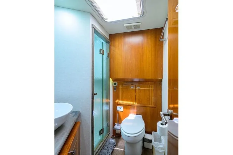 Slide: The Image of Bathroom interior of 1998 Hatteras 70 Cockpit Motor Yacht with wooden cabinetry and glass shower. - 43