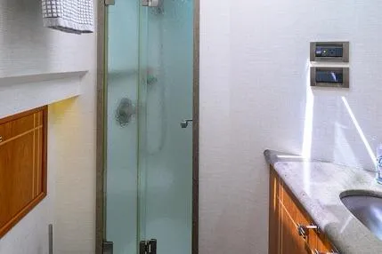 Slide: The Image of 1998 Hatteras 70 Cockpit Motor Yacht bathroom with glass shower and wooden cabinetry. - 44