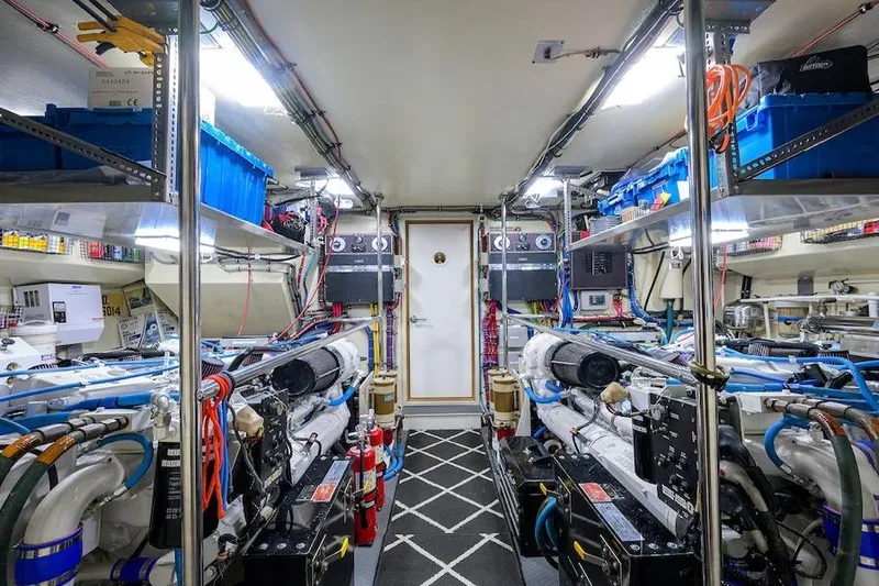 Slide: The Image of Engine room of 1998 Hatteras 70 Cockpit Motor Yacht, featuring organized equipment and storage. - 45