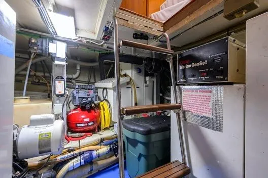 Slide: The Image of Engine room of 1998 Hatteras 70 Cockpit Motor Yacht with equipment and ladder. - 48