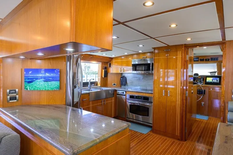 Slide: The Image of Luxurious interior of 1998 Hatteras 70 Cockpit Motor Yacht with modern kitchen amenities. - 6