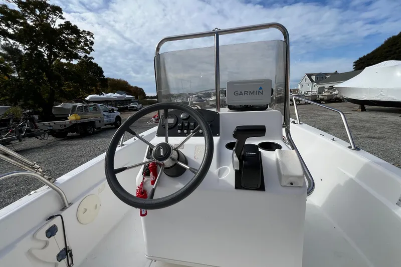 Slide: The Image of 2001 Boston Whaler 16 Dauntless boat console with Garmin navigation, parked outdoors. - 16