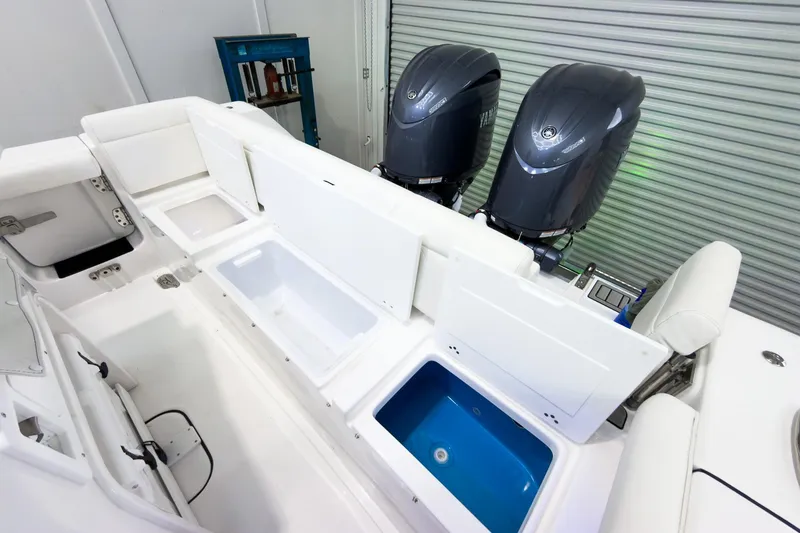 Slide: The Image of 2026 Tidewater 256 LXF boat interior with dual engines and open storage compartments. - 13