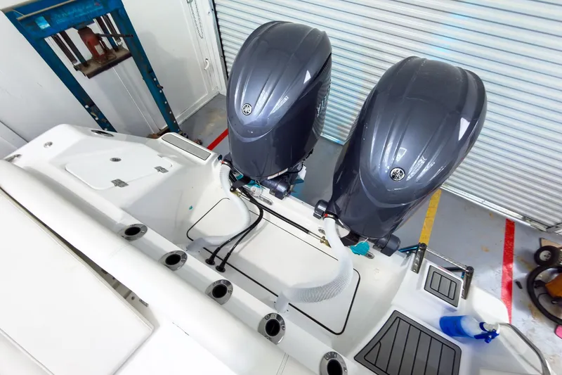 Slide: The Image of 2026 Tidewater 256 LXF boat with dual outboard engines in a garage setting. - 14