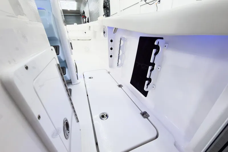 Slide: The Image of 2026 Tidewater 256 LXF boat interior with storage compartments and sleek white design. - 25