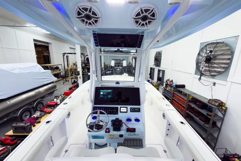 Slide: The Image of 2026 Tidewater 256 LXF boat interior with advanced navigation system in a workshop setting. - 28
