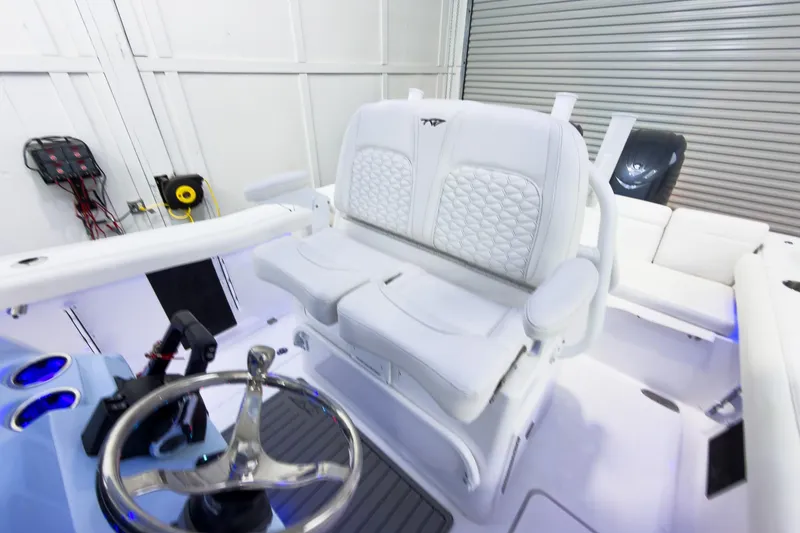 Slide: The Image of 2026 Tidewater 256 LXF boat interior with white seating and steering wheel. - 31