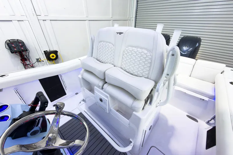 Slide: The Image of 2026 Tidewater 256 LXF boat interior with white cushioned seating and steering wheel. - 32