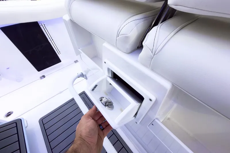 Slide: The Image of 2026 Tidewater 256 LXF boat interior with storage compartment and cushioned seating. - 34