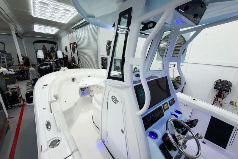 Slide: The Image of 2026 Tidewater 256 LXF boat interior in a workshop with advanced controls and seating. - 43