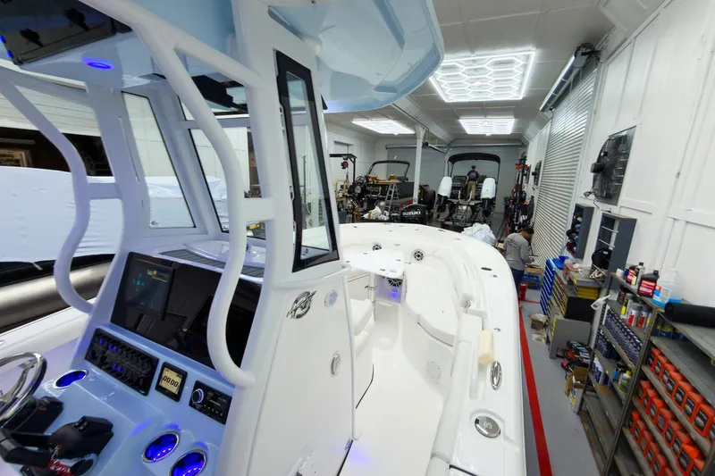 Slide: The Image of 2026 Tidewater 256 LXF boat in a well-equipped garage with modern lighting. - 44