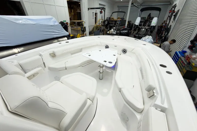 Slide: The Image of 2026 Tidewater 256 LXF boat interior with white seating and table in a workshop. - 47
