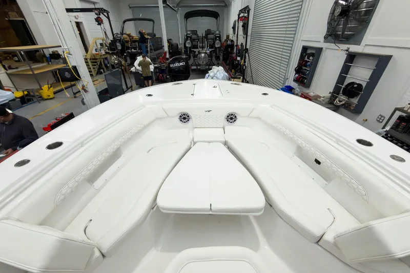 Slide: The Image of 2026 Tidewater 256 LXF boat interior with white seating in a workshop setting. - 54
