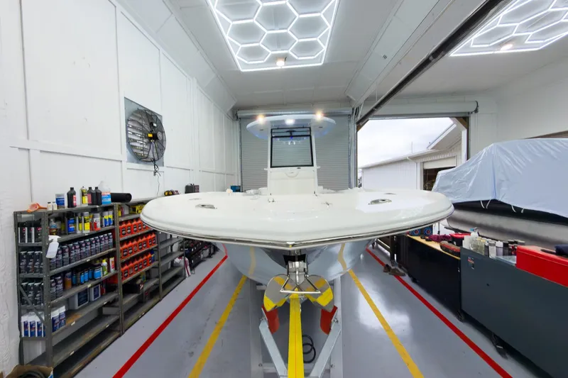 Slide: The Image of 2026 Tidewater 256 LXF boat in a well-lit garage with organized shelves. - 8