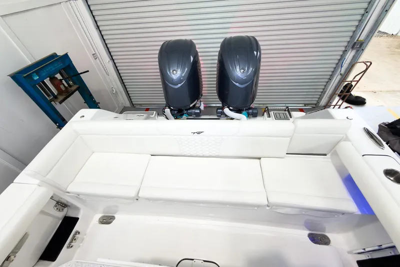 Slide: The Image of 2026 Tidewater 256 LXF boat with dual engines and white seating in a garage. - 9