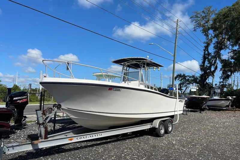 The Image of 1995 Mako 248 boat on trailer under clear blue sky. - 0