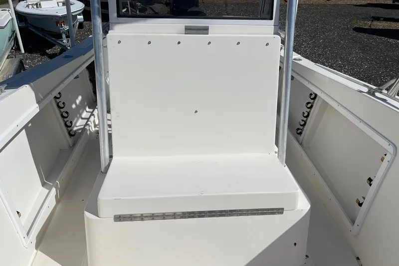 Slide: The Image of 1995 Mako 248 boat interior with white seating and rod holders. - 1