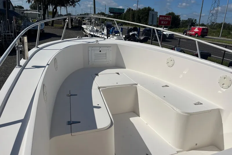 Slide: The Image of 1995 Mako 248 boat interior with white seating and storage compartments. - 2