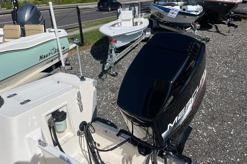 Slide: The Image of Boat dealership lot featuring a 1995 Mako 248 with Mercury outboard motor. - 3