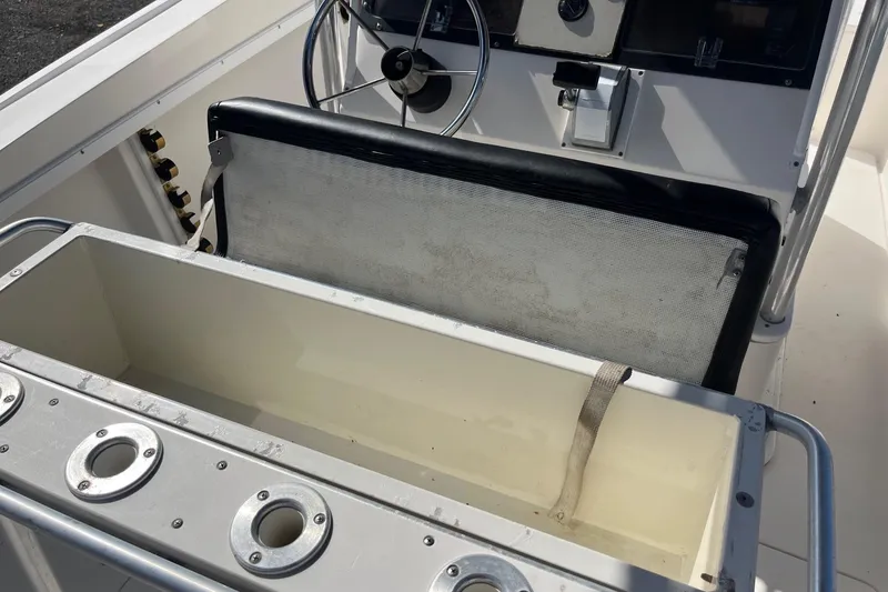 Slide: The Image of 1995 Mako 248 boat interior with steering wheel and storage compartment. - 4