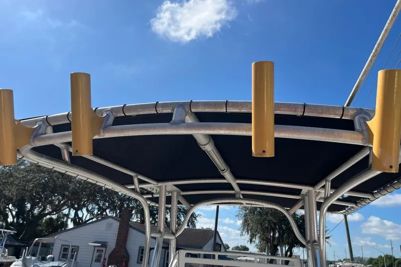 Slide: The Image of T-top of a 1995 Mako 248 boat with rod holders under a clear blue sky. - 5