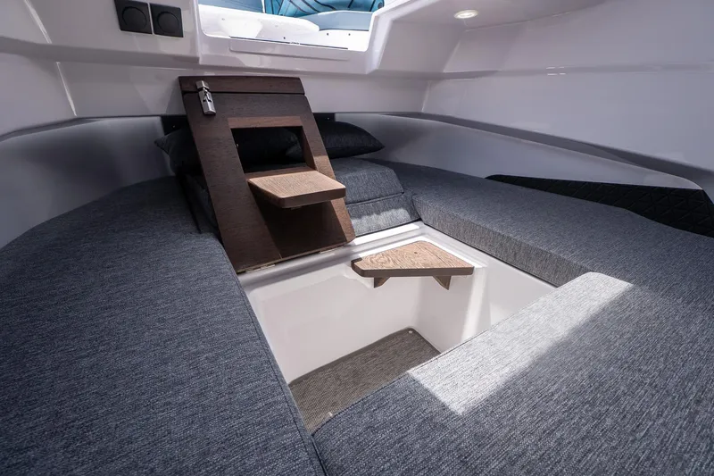 Slide: The Image of 2026 Axopar 29 Cross Cabin interior with gray seating and wooden accents. - 21