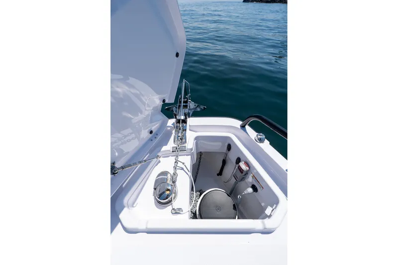 Slide: The Image of Anchor compartment of 2026 Axopar 29 Cross Cabin on calm water. - 26