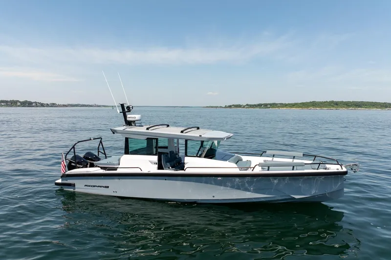Slide: The Image of 2026 Axopar 29 Cross Cabin boat on calm water under clear sky. - 3